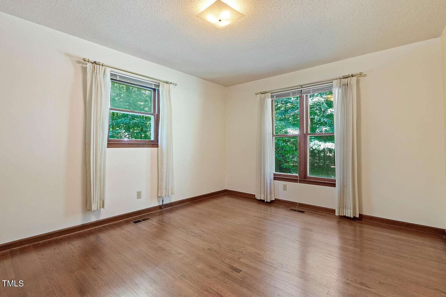 6013 Splitrock Trail Apex, NC 27539 - Photo 40 of 53 an empty room with wooden floor and windows