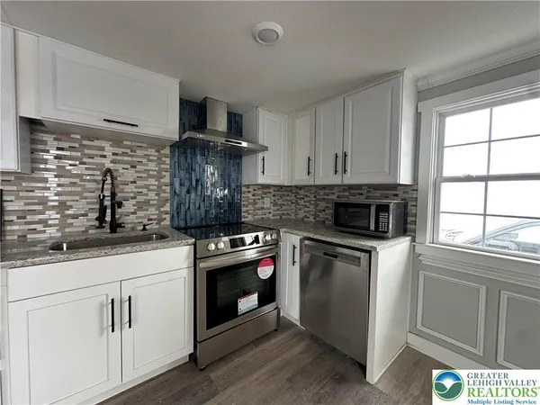 a kitchen with white cabinets stainless steel appliances and sink