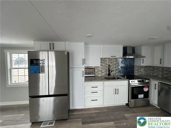 a kitchen with stainless steel appliances granite countertop a refrigerator stove a sink and dishwasher