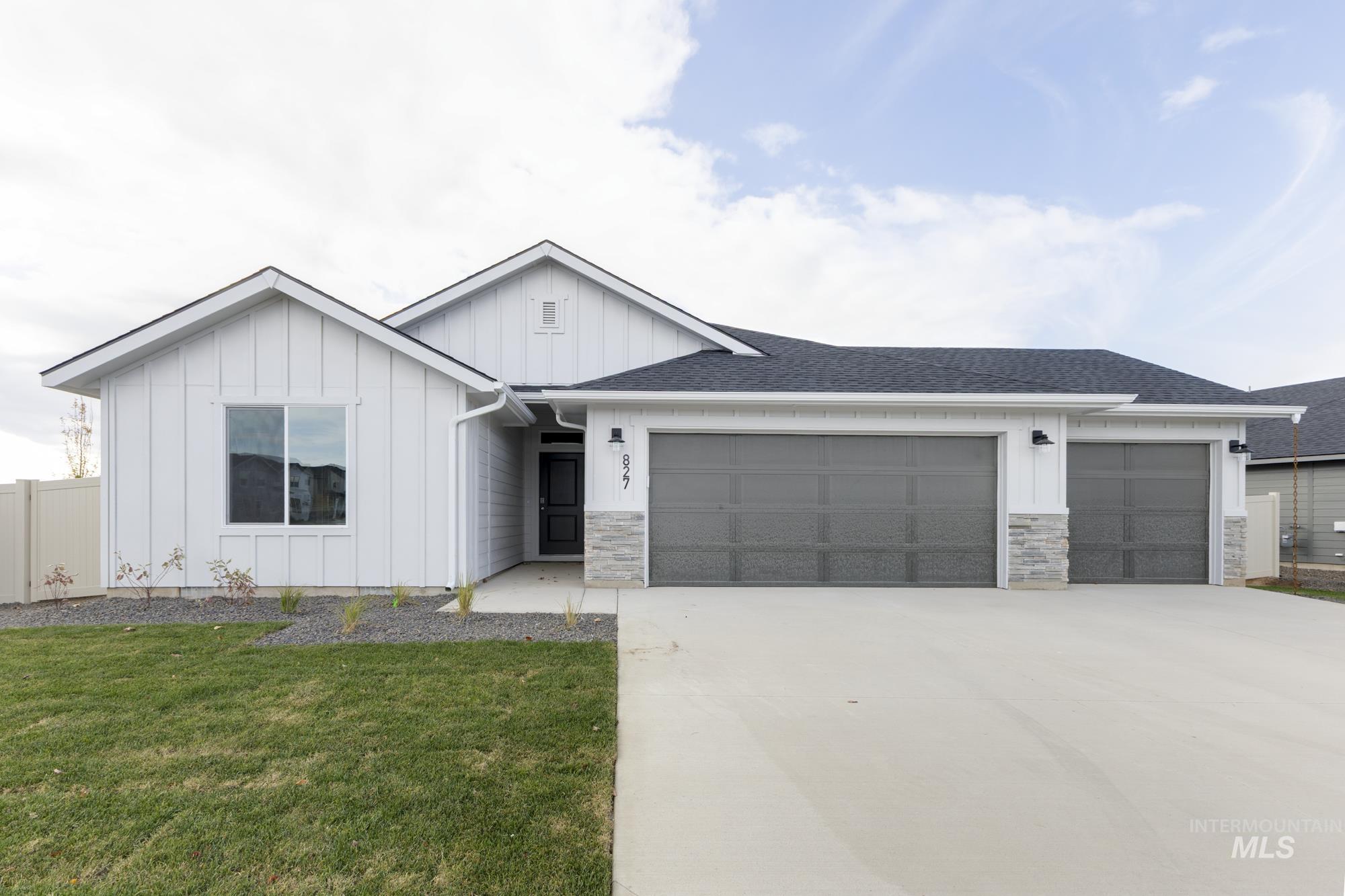 827 North Aleppo Way Meridian, ID 83642 - Photo 1 of 1 View of front of home featuring board and batten siding, a garage, driveway, roof with shingles, and stone siding