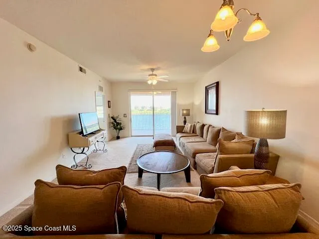 a living room with furniture a lamp and a chandelier