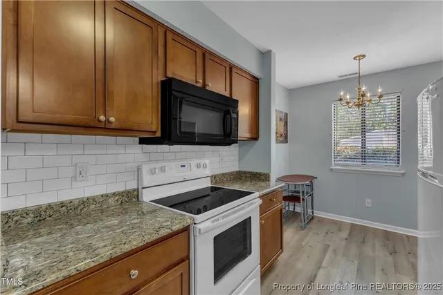 a kitchen with stainless steel appliances granite countertop a sink stove and microwave