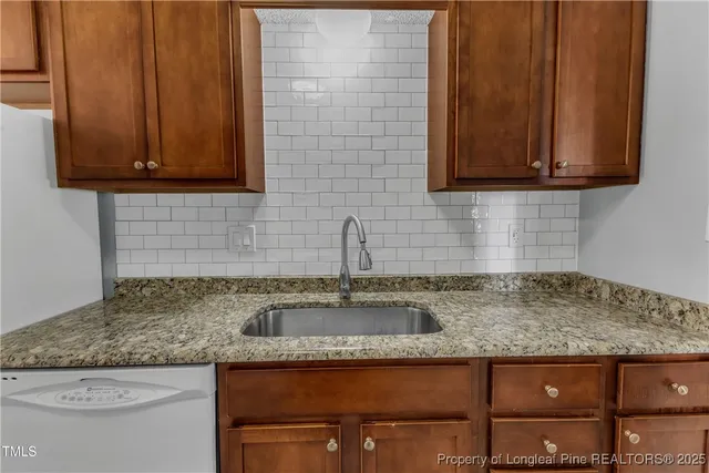 a kitchen with granite countertop wooden cabinets and a sink