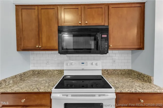 a kitchen with granite countertop wood cabinets and stainless steel appliances
