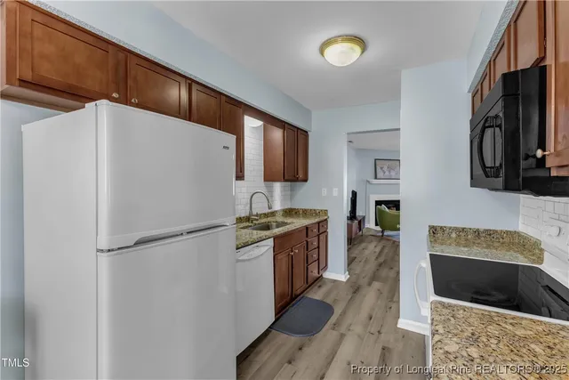 a kitchen with stainless steel appliances granite countertop a refrigerator a stove a sink and a microwave