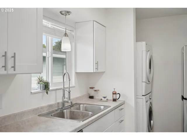 a kitchen with stainless steel appliances granite countertop a sink and a refrigerator