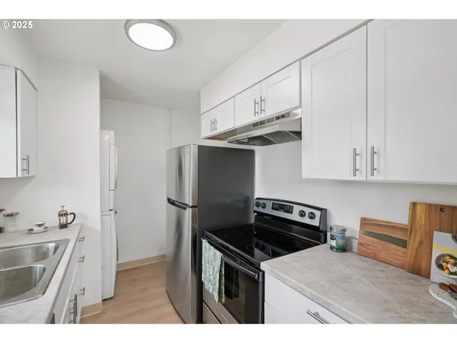 a kitchen with a sink a refrigerator and cabinets