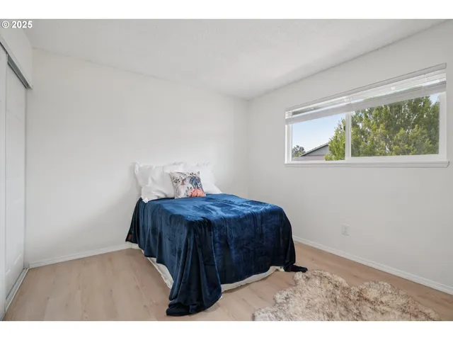 a bed sitting in a bedroom next to a window