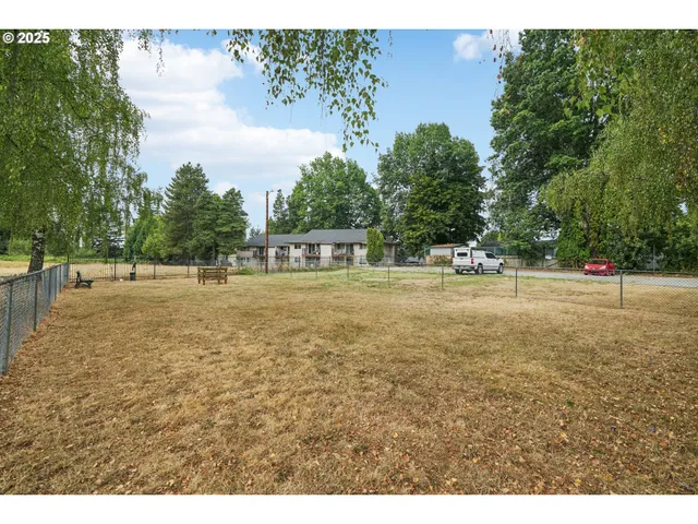 a view of green field with trees in the background