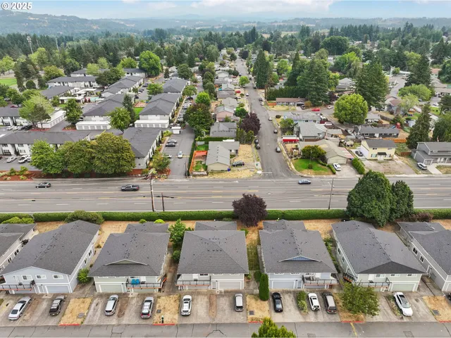 an aerial view of residential houses with outdoor space and parking