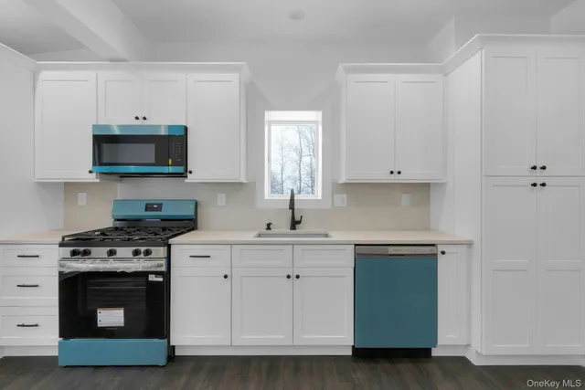 a kitchen with white cabinets and a stove top oven