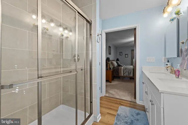 a en suite bathroom with a shower sink and mirror