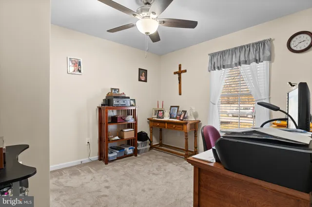 a view of a workspace with furniture and a window