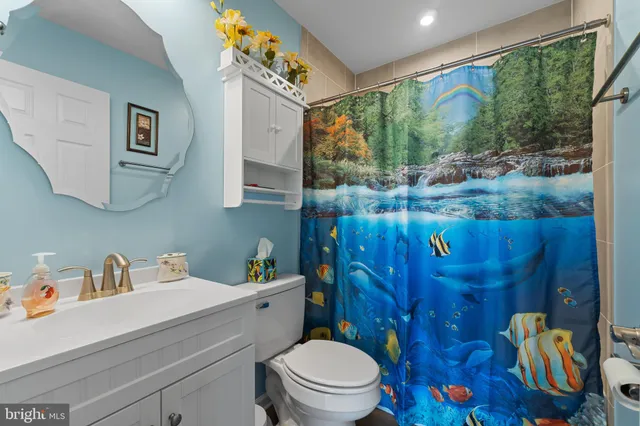 a bathroom with a granite countertop sink mirror vanity and toilet