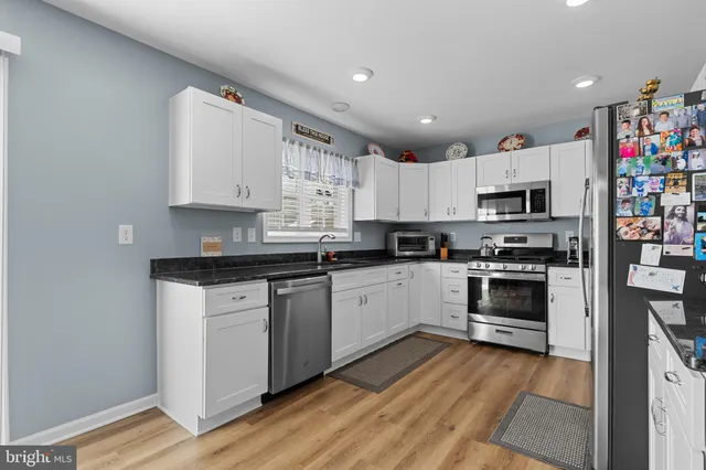 a kitchen with granite countertop white cabinets and white appliances