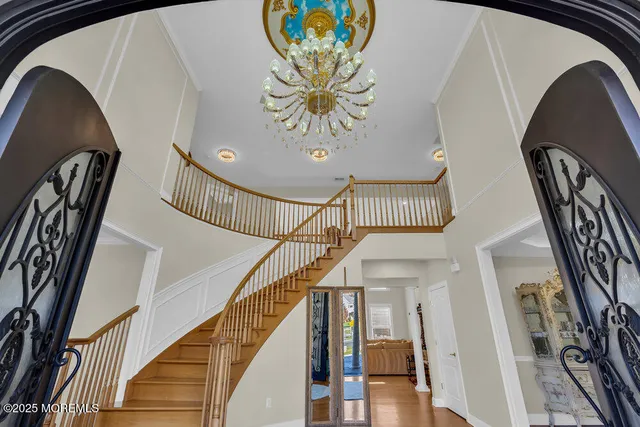 a view of a dining room with furniture a chandelier and wooden floor