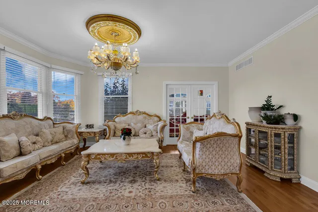 a open kitchen with stainless steel appliances granite countertop a stove top oven a sink dishwasher a dining table and chairs with wooden floor