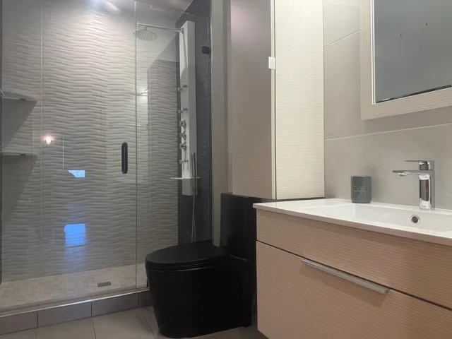 a bathroom with a sink a toilet and shower