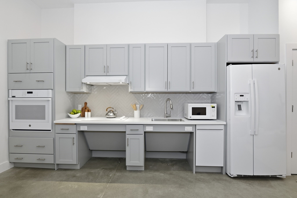 10 Stonley Road, Unit 102 Boston, MA 02130 - Photo 6 of 13 a kitchen with cabinets and white appliances