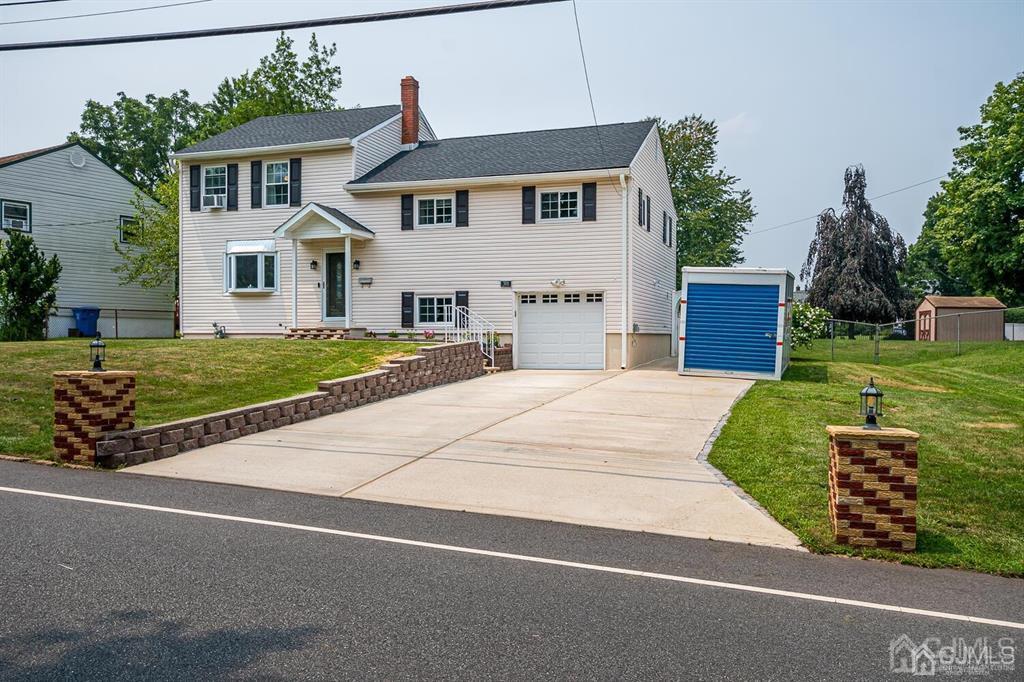 301 Colonia Boulevard Colonia, NJ 07067 - Photo 8 of 51 a front view of a house with a yard and garage
