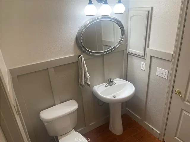 a kitchen with stainless steel appliances granite countertop a refrigerator a stove a sink a dining table and chairs with wooden floor