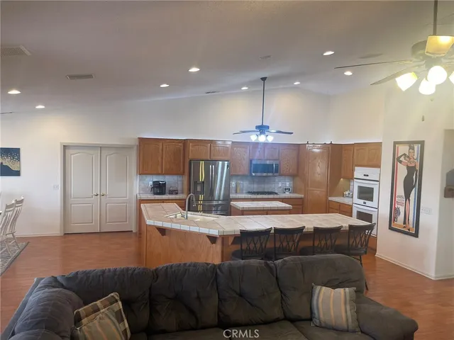 a living room with furniture a chandelier and a flat screen tv
