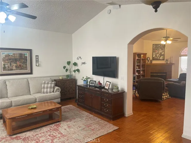 a room with a desk and chandelier fan