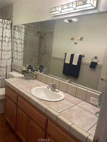 a living room with furniture a flat screen tv and a floor to ceiling window