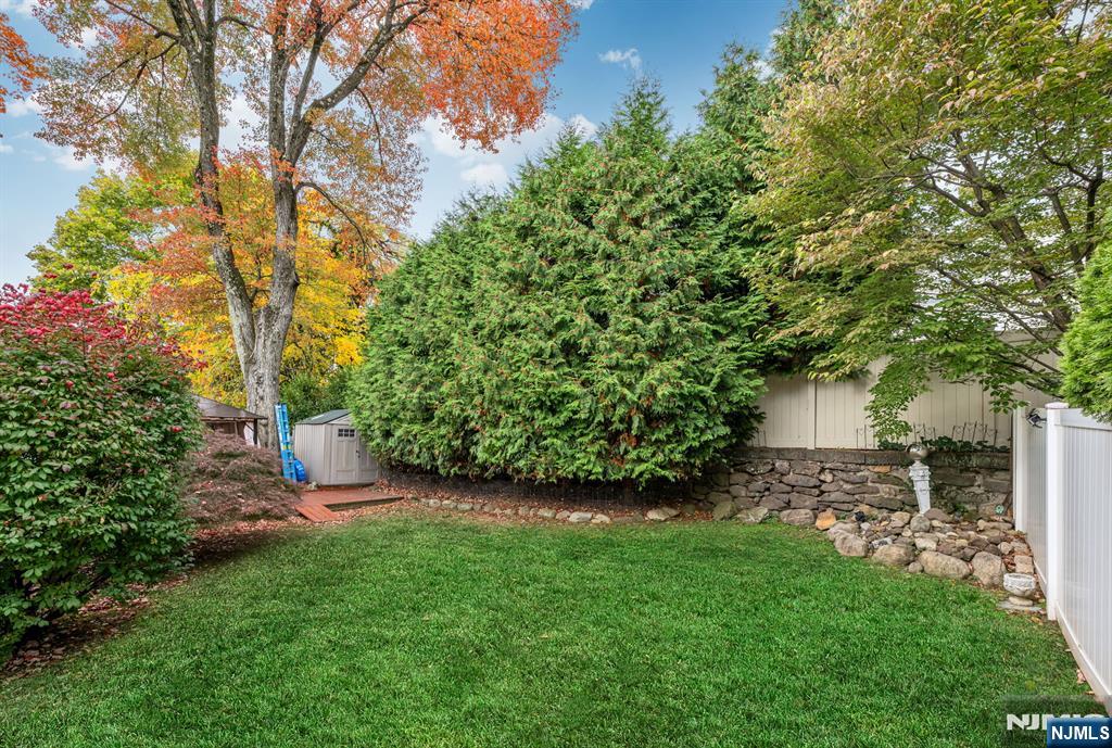 431 Goffle Road Wyckoff, NJ 07481 - Photo 17 of 19 a view of a backyard with table and chairs and a large tree