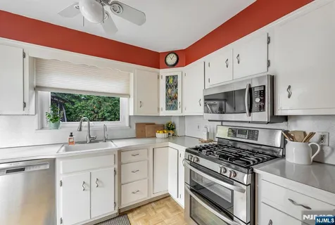 a kitchen with white cabinets and appliances