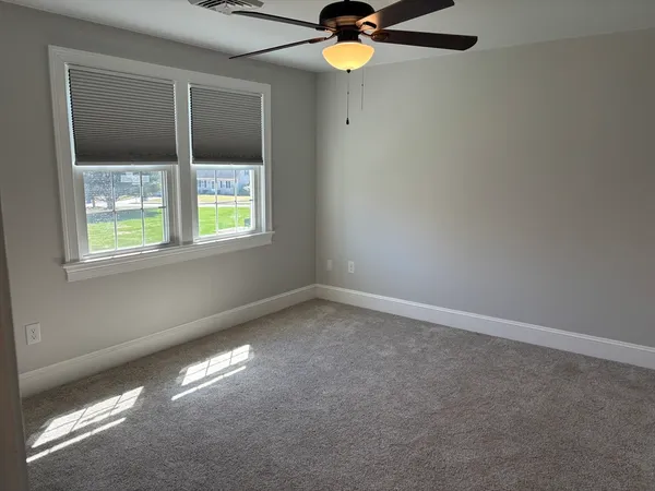 en empty room with windows and fan