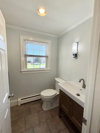 a bathroom with a sink toilet and window