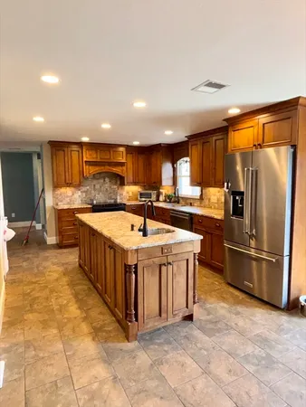 a kitchen with stainless steel appliances granite countertop a sink a stove and a refrigerator