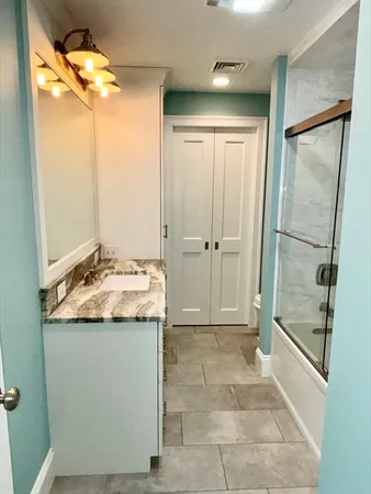 a bathroom with a granite countertop sink and a mirror