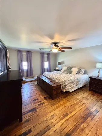a bedroom with a bed and wooden floor