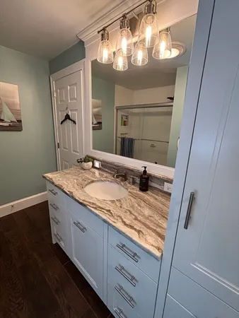 a bathroom with a granite countertop sink and a mirror