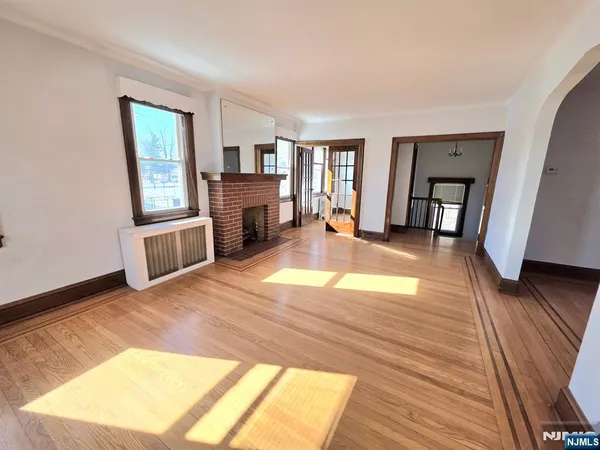 a view of a livingroom with wooden floor and a fireplace