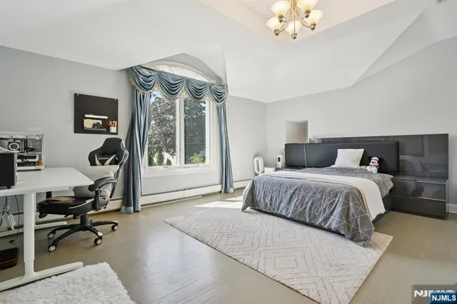 a bedroom with a large bed and a chandelier