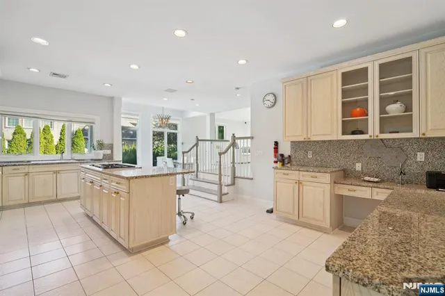 a kitchen with stainless steel appliances granite countertop a stove a sink and a refrigerator