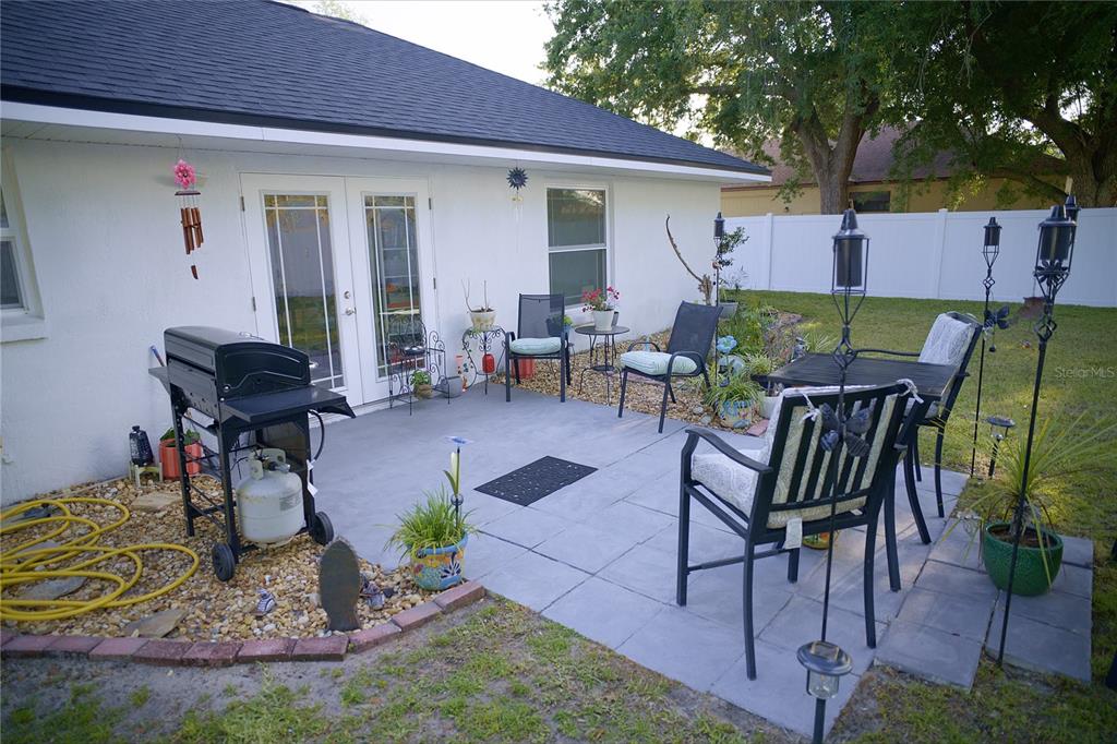 408 Raymond Street Minneola, FL 34715 - Photo 12 of 21 a view of a patio with table and chairs potted plants and a large tree