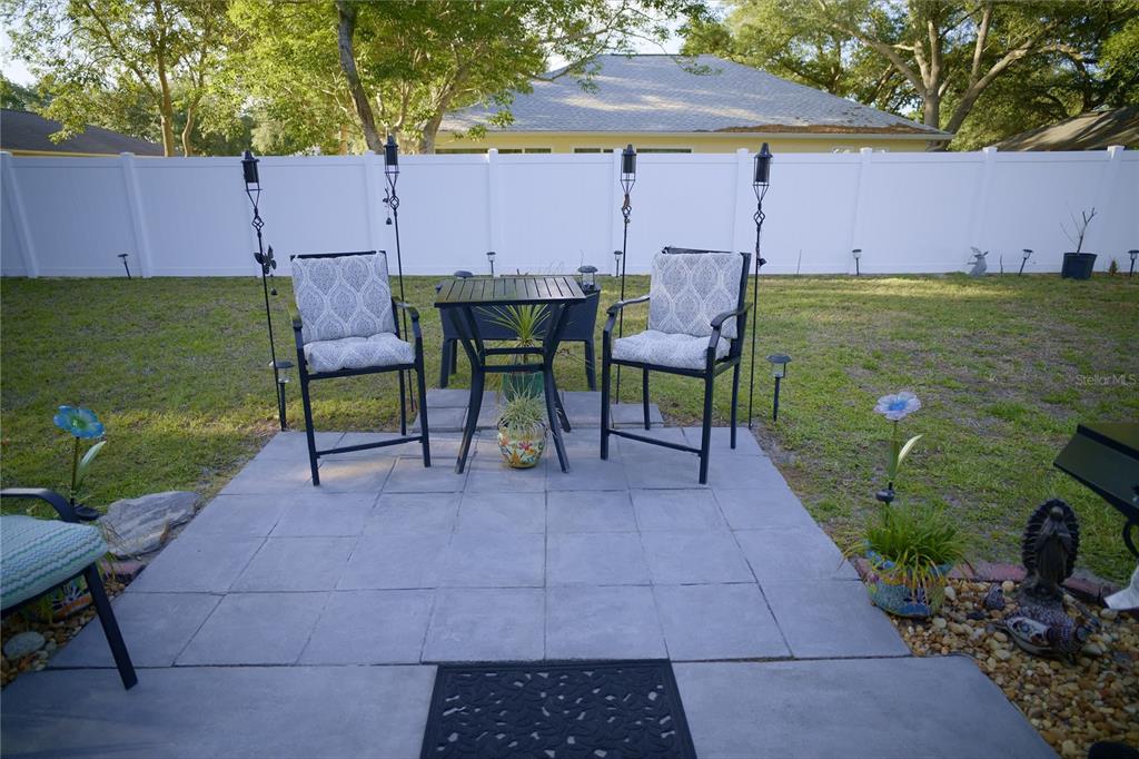 408 Raymond Street Minneola, FL 34715 - Photo 18 of 21 a view of a patio with table and chairs under an umbrella