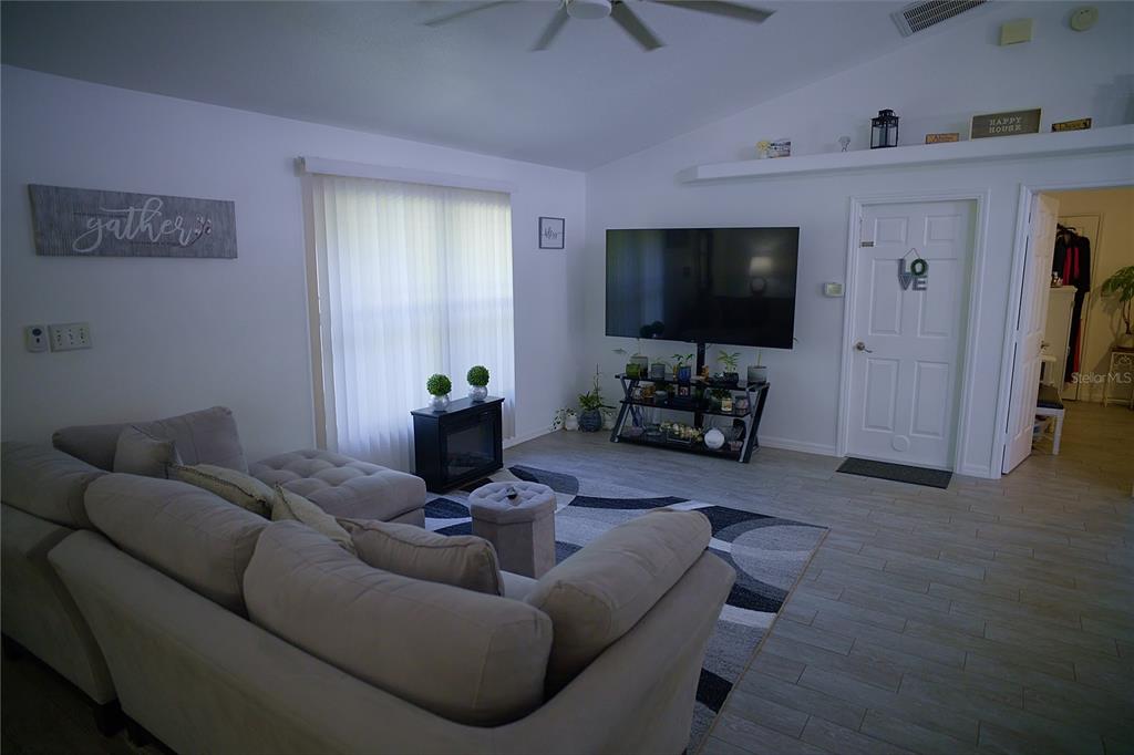 408 Raymond Street Minneola, FL 34715 - Photo 8 of 21 a living room with furniture and a flat screen tv