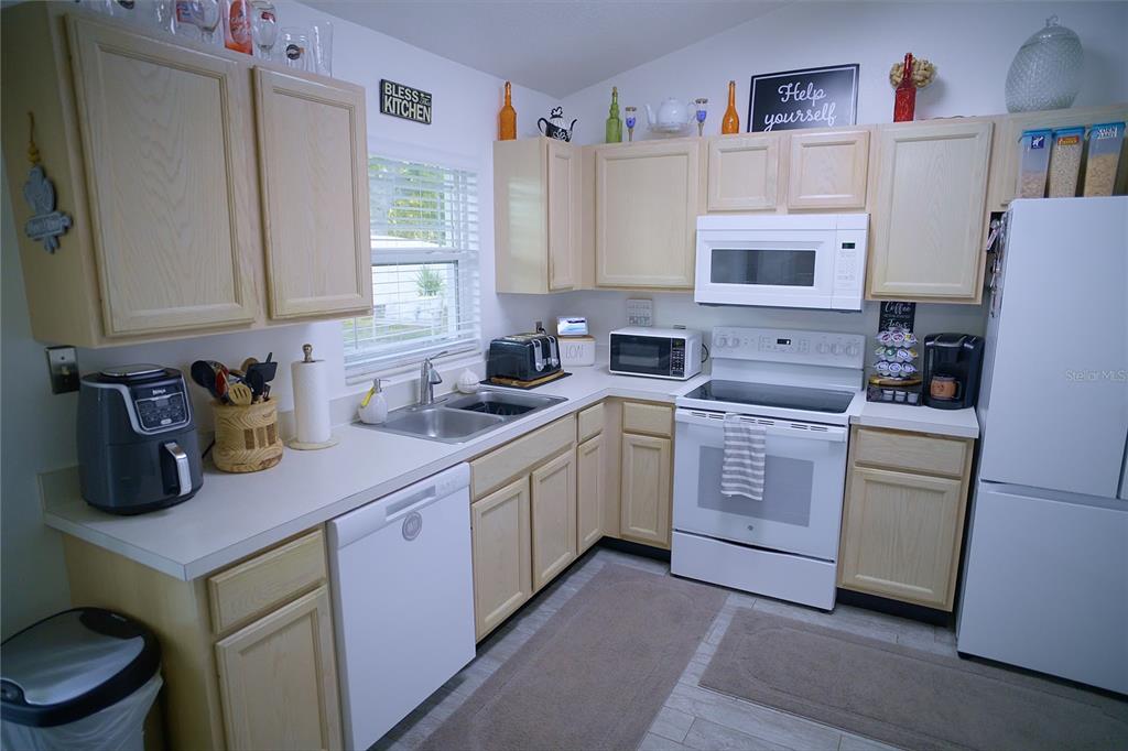 408 Raymond Street Minneola, FL 34715 - Photo 10 of 21 a kitchen with a sink stove and cabinets