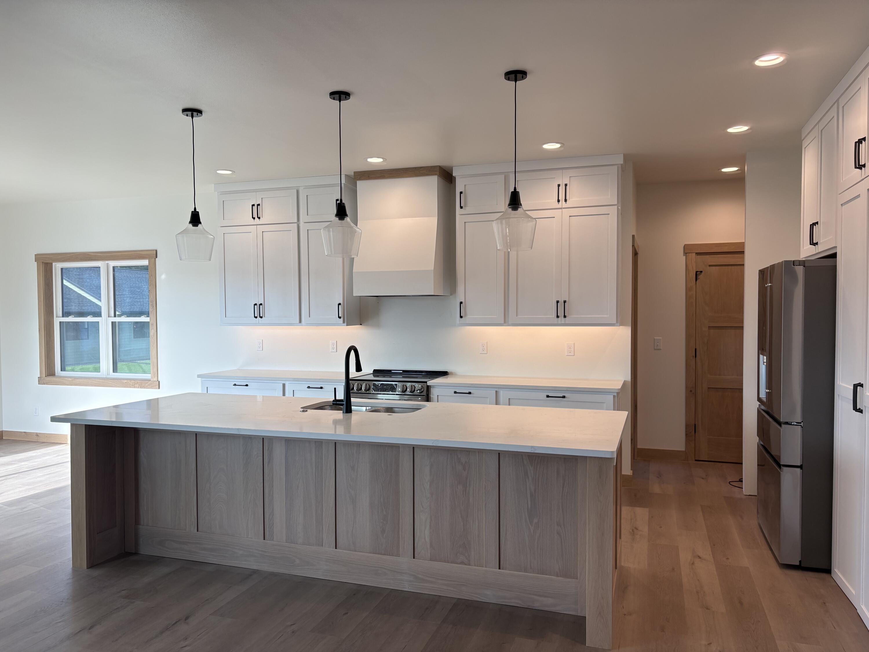 286 Weston Road Holmen, WI 54636 - Photo 5 of 7 Kitchen with white perimeter cabinetry and white oak island.