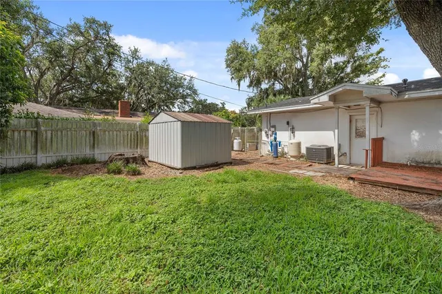 a view of a backyard with a garden and tree