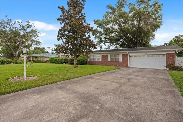 a view of a house with backyard and trees