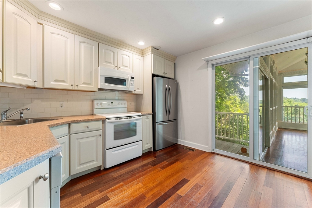 20 Morses Pond Road Natick, MA 01760 - Photo 5 of 15 a kitchen with wooden floors and white cabinets