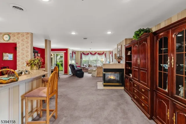 a living room with furniture a flat screen tv and a refrigerator