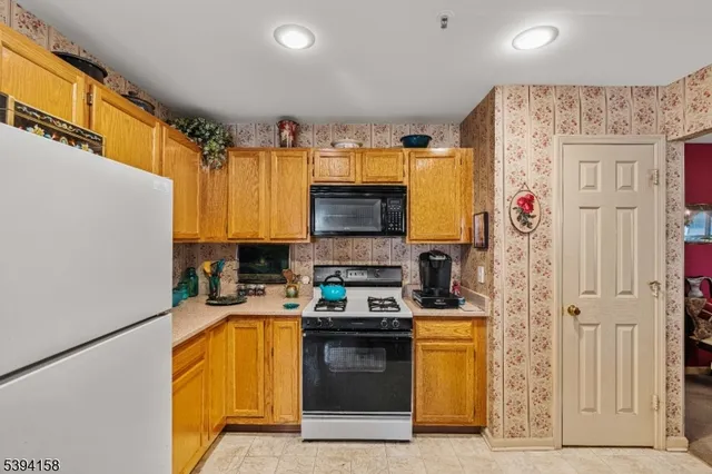 a kitchen with a refrigerator a stove top oven a sink and cabinets