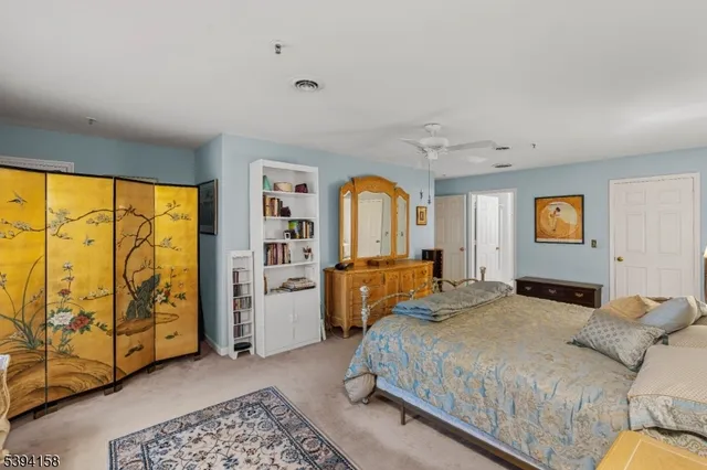 a spacious bedroom with a bed a dresser and next to a window